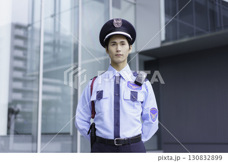 オフィスビルの外に立って敬礼する若い警備員のポートレート　撮影協力:スカパー東京メディアセンター 130832899