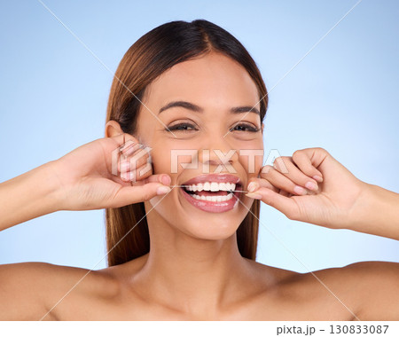 Dental floss, portrait and woman smile with teeth hygiene, healthcare and wellness treatment. Isolated, blue background and studio with a female feeling beauty from a clean mouth with self care Dental floss, portrait and woman smile with teeth hygiene, healthcare and wellness treatment. Isolated, blue background and studio with a female feeling beauty from a clean mouth with self care 130833087