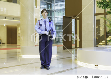 オフィスビルのロビーに立つ若い女性警備員　撮影協力：学校法人電波学園 東京電子専門学校 130833095