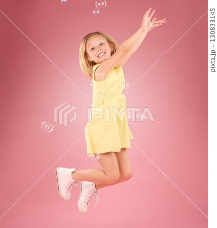 Child, jump and bubbles for a smile portrait in studio with a pink background for fun. Female kid model jumping with happiness, play and cheerful face isolated on gradient color and space Child, jump and bubbles for a smile portrait in studio with a pink background for fun. Female kid model jumping with happiness, play and cheerful face isolated on gradient color and space 130833145