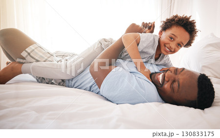 Children, love and bedroom with a playful black family having fun in the morning together after waking up. Kids, smile or laughing with a father and happy son playing or joking on a bed in their home 130833175