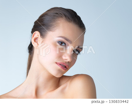 Makeup, portrait and woman in studio for skincare, wellness or cosmetic on blue background. Face, beauty and girl model with luxury, dermatology or product satisfaction or skin routine while isolated Makeup, portrait and woman in studio for skincare, wellness or cosmetic on blue background. Face, beauty and girl model with luxury, dermatology or product satisfaction or skin routine while isolated 130833442