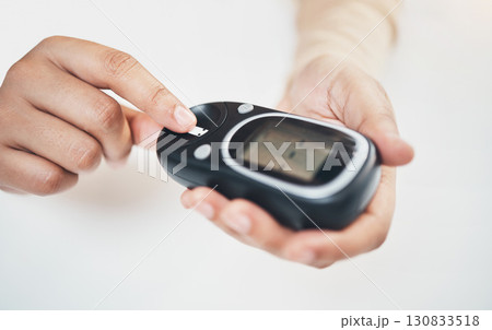 Diabetes, blood test and medical with finger of woman for insulin level, monitoring and glucose check. Medicine, healthcare and digital with hands of patient and glucometer machine for sugar balance 130833518