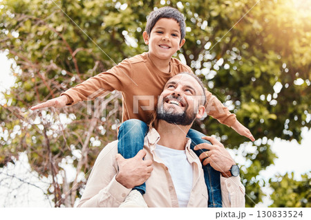 Father, child and happy back ride in nature for family bonding time, summer break or holiday together outdoors. Happy dad carrying son on piggyback with smile enjoying vacation in the park outside 130833524