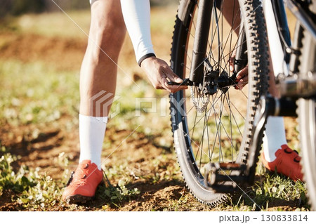 Man, hands and mountain bike wheel repair in park for training, triathlon sports gear and workout exercise. Cyclist, bicycle and check tire chain for travel safety, cycling maintenance and fixing hub Man, hands and mountain bike wheel repair in park for training, triathlon sports gear and workout exercise. Cyclist, bicycle and check tire chain for travel safety, cycling maintenance and fixing hub 130833814
