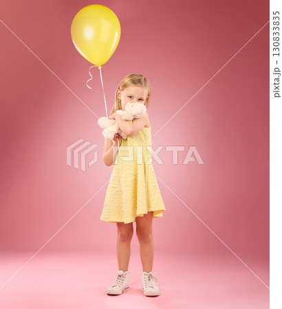 Teddy bear kiss, balloon and girl portrait with a soft toy with happiness and love for toys in a studio. Isolated, pink background and a young female child feeling happy, joy and cheerful with friend 130833835