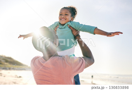 Black man, girl and airplane game at ocean on playful family holiday in Australia with freedom and energy. Travel, fun and happy father and child with smile playing and bonding together on vacation. 130833898