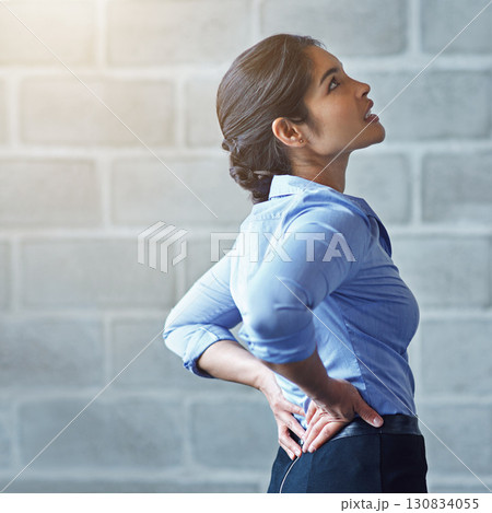 Back pain, office stress and business woman with muscle injury, health risk and fatigue on mockup wall. Uncomfortable female worker, spine problem and bad posture of injured body, scoliosis and joint 130834055