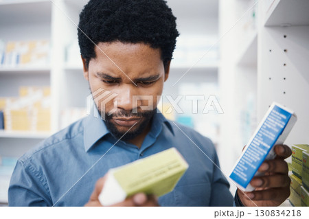 Black man, pharmacy stock check and pharmacist in a wellness, healthcare and drugs clinic. Reading, medical information and a retail pharmaceutical worker with pills storage and store supplements 130834218