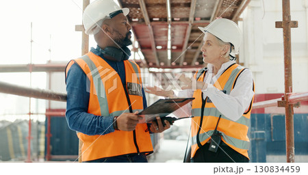 Construction, inspection and man with checklist talking to woman in engineering on site with scaffolding and building renovation. Contractor, survey and list of industrial maintenance safety rules 130834459