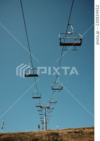 Ski lift chairs stretching across the blue summer sky on Stara Planina, symbolizing adventure and winter tourism in the Balkan mountains. Serbia country 130834912