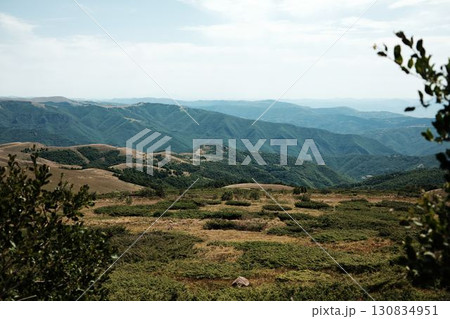 Panoramic view of Stara Planina with rolling green hills and mountain ridges under a soft cloudy sky. Serbia country. 130834951