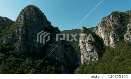 Close aerial view of dramatic rocky cliffs in Jerma Canyon mountains, Serbia country, surrounded by dense forest Close aerial view of dramatic rocky cliffs in Jerma Canyon mountains, Serbia country, surrounded by dense forest 130835106