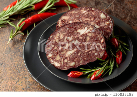 Blood sausage with meat offal accompanied by rosemary and red pepper. Blood sausage with meat offal accompanied by rosemary and red pepper. 130835188