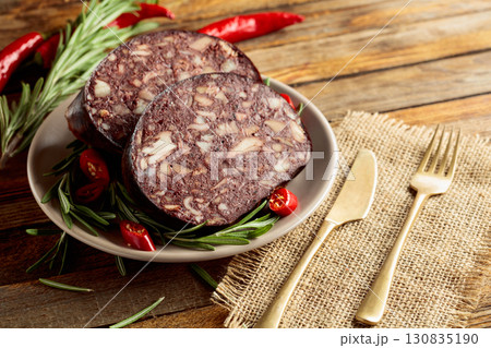 Black pudding or blood sausage accompanied by rosemary and red pepper. Black pudding or blood sausage accompanied by rosemary and red pepper. 130835190