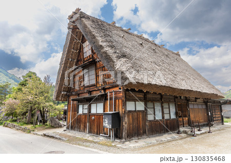 Typical traditional thick gassho zukuri style roof in Shirakawago in Japan during springtime. Typical traditional thick gassho zukuri style roof in Shirakawago in Japan during springtime. 130835468