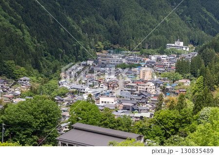 Close-up aerial view of Gujo Hachiman town, a small riverside town in Gifu Prefecture, Japan, known for its pristine waterways Close-up aerial view of Gujo Hachiman town, a small riverside town in Gifu Prefecture, Japan, known for its pristine waterways 130835489