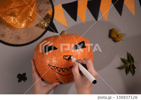 Drawing Scary Face on Pumpkin for Halloween Decoration at Home Drawing Scary Face on Pumpkin for Halloween Decoration at Home 130837126