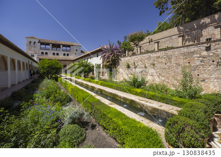 Alhambra Gardens showcasing moorish architecture and lush vegetation in Granada, Spain Alhambra Gardens showcasing moorish architecture and lush vegetation in Granada, Spain 130838435