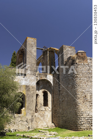 Ruins of the ancient aqueduct of Serpa showing arches and weathered stone walls against blue sky 130838453