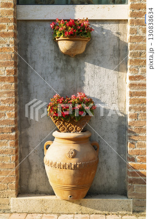 Terracotta vases with flowers decorating a wall in Pienza, Tuscany 130838634