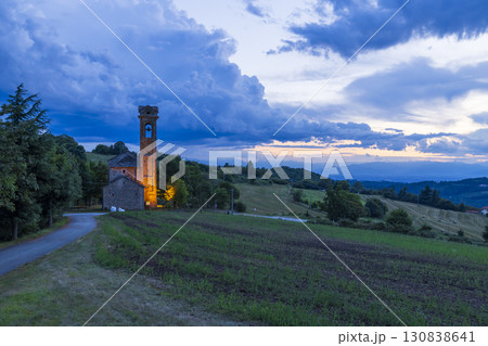 Illuminated Church Stands on Hilltop in Piedmont, Italy at Dusk Illuminated Church Stands on Hilltop in Piedmont, Italy at Dusk 130838641