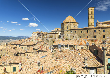Volterra medieval skyline with tiled roofs and church under blue summer sky Volterra medieval skyline with tiled roofs and church under blue summer sky 130838675