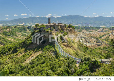 Civita di Bagnoregio standing on a plateau and connected by a bridge in a sunny summer day 130838709