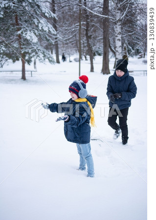 Two children playing in a snowy park, enjoying winter's wonderland. Two children playing in a snowy park, enjoying winter's wonderland. 130839439