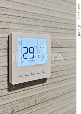 Smart digital thermostat installed on modern textured wall Smart digital thermostat installed on modern textured wall 130839562