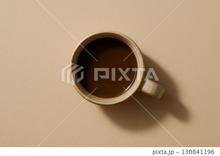 Top view of black coffee in ceramic cup on beige background with copy space. Minimalist coffee break concept. 130841196