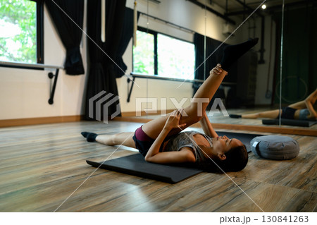 Wellness and mindfulness concept with woman practicing yoga indoors peacefully 130841263