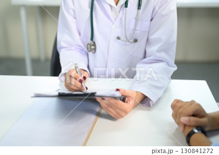 Close up of doctor writing notes on a clipboard during patient consultation 130841272
