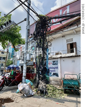 カンボジア・プノンペンの街角に見られる、複雑に絡み合った電線と電柱のユニークな東南アジアの風景写真 カンボジア・プノンペンの街角に見られる、複雑に絡み合った電線と電柱のユニークな東南アジアの風景写真 130841401