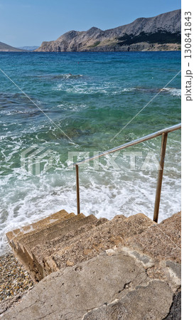 Stone steps descending into the sea 130841843