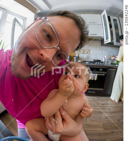 Joyful Father Holding Baby in Kitchen Joyful Father Holding Baby in Kitchen 130842246