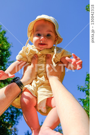 Joyful Baby Lifted in the Air Outdoors Joyful Baby Lifted in the Air Outdoors 130842318
