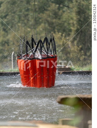 Firefighting Water Bucket Dips into River Scene 130842324