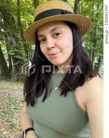 Woman in Straw Hat Smiling in Forest Woman in Straw Hat Smiling in Forest 130842397