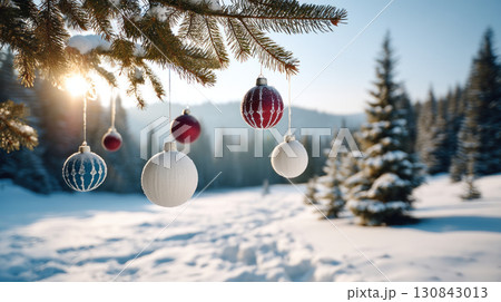 Christmas tree ornament hanging on pine branch with snow and sunlight in winter forest landscape Christmas tree ornament hanging on pine branch with snow and sunlight in winter forest landscape 130843013