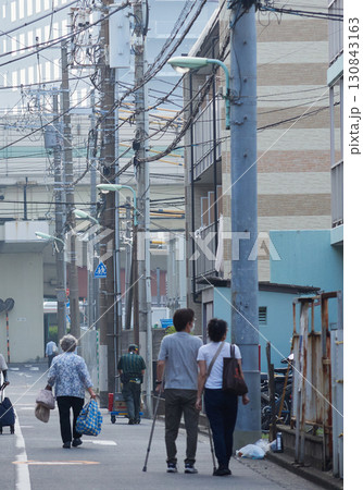 夏の朝の都市の商店街で歩くシニア女性と人々の姿 夏の朝の都市の商店街で歩くシニア女性と人々の姿 130843163