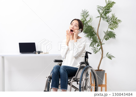 車椅子に女性　在宅ワーク　通話　驚く 130843484