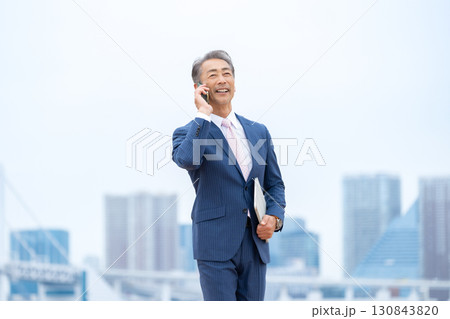 ビジネスマン　ビル群　スマホ 130843820