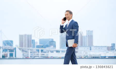 ビジネスマン　ビル群　スマホ 130843821