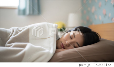 布団で安らかに眠る女性のライフスタイルイメージ 130844172