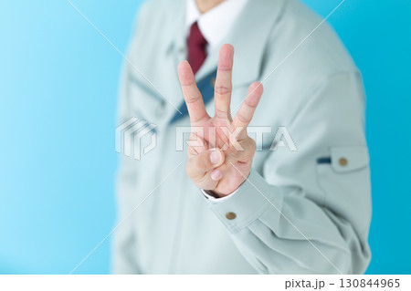 3本指を立てる作業着姿のミドル男性ビジネスマン 130844965