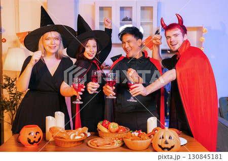 Dinner and group of people celebrating together at Halloween party. Dinner and group of people celebrating together at Halloween party. 130845181