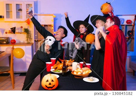 Dinner and group of people celebrating together at Halloween party. Dinner and group of people celebrating together at Halloween party. 130845182