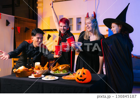 Dinner and group of people celebrating together at Halloween party. 130845187