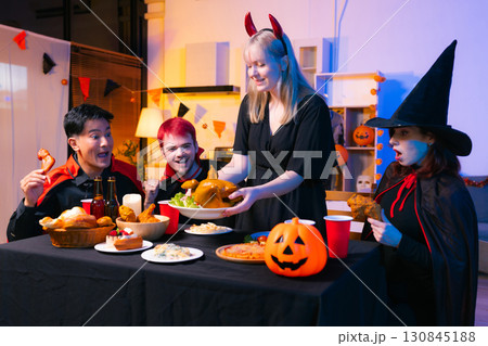 Dinner and group of people celebrating together at Halloween party. 130845188